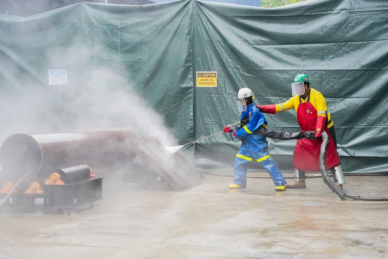 Technicians undertaking water-jet cleaning at an industrial site